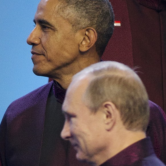 Russian President Vladimir Putin walks past U.S. President Barack Obama during the Aisa-Pacific Economic Cooperation (APEC) Summit family photo, Monday, Nov. 10, 2014 in Beijing. (AP Photo/Pablo Marti ...