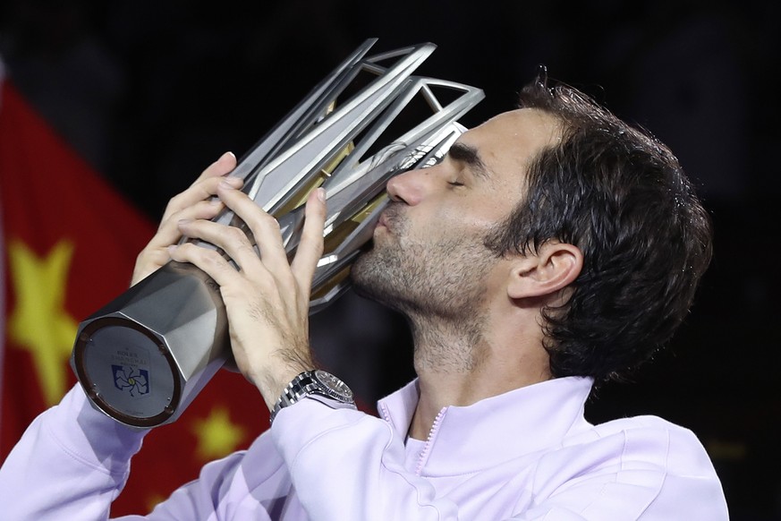 Roger Federer of Switzerland kisses his trophy after defeating Rafael Nadal of Spain in their men&#039;s singles final match to win the Shanghai Masters tennis tournament at Qizhong Forest Sports City ...