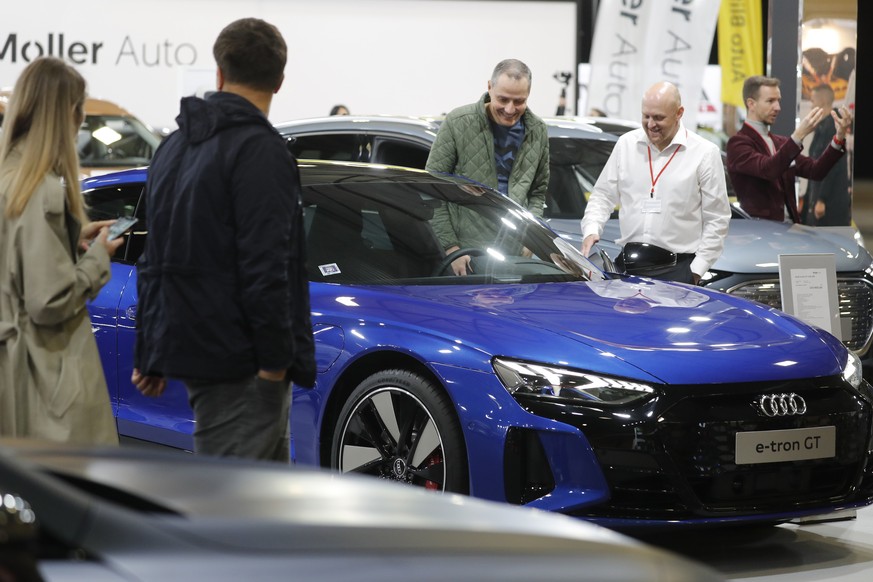 epa09485862 People look at the Audi e-tron GT Electric Sportback displayed at the International Motor Show Auto 2021 in Riga, Latvia, 24 September 2021. The automotive industry event Auto 2021 is the  ...