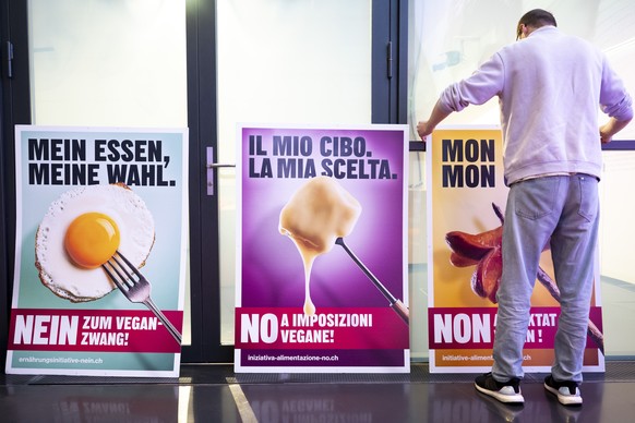 KEYPIX - Eine Person bringt vor einer Medienkonferenz Plakate mit der Aufschrift 'Nein zum Vegan-Zwang' auf Deutsch, Italienisch und Franzoesisch an, kurz vor einer Medienkonferenz des Komit ...