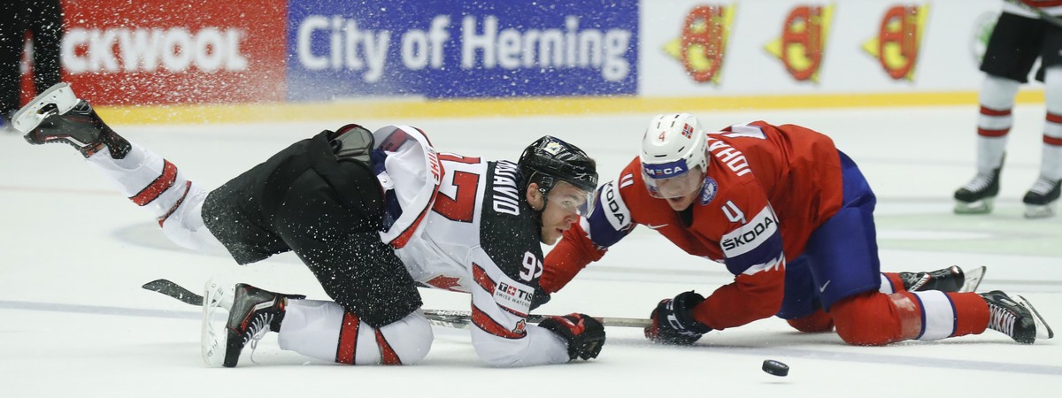 Canada's Connor McDavid, left, challenges for the puck with Norway's Johannes Johannesen, right, during the Ice Hockey World Championships group B match between Norway and Canada at the Jysk ...