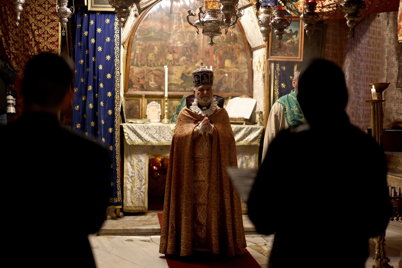 epaselect epa12610644 Christian clerics pray at the Grotto in the Church of the Nativity on Christmas Eve in the West Bank city of Bethlehem, 24 December 2025. The Church of the Nativity is one of the ...