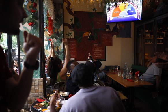 epa11465677 French people react after the second round of the legislative elections results in Paris, France, 07 July 2024. France voted on 07 July for the second round of the legislative elections. A ...