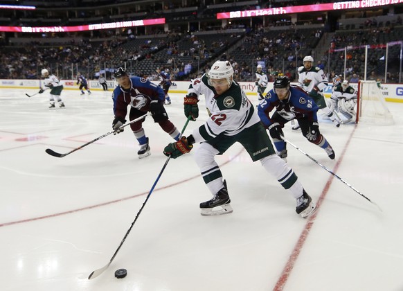 Minnesota Wild right wing Nino Niederreiter, front, reaches out to control the puck with Colorado Avalanche right wing Jarome Iginla, back left, and left wing Gabriel Landeskog, of Sweden, in pursuit  ...
