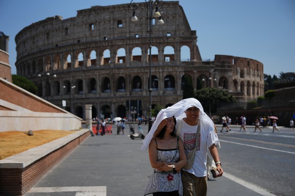 Tourists take shelter as they walk in front of the Rome'a ancient Colosseum, Saturday, Aug. 1, 2026. (AP Photo/Alessandra Tarantino)
APTOPIX Italy Extreme Weather Heat