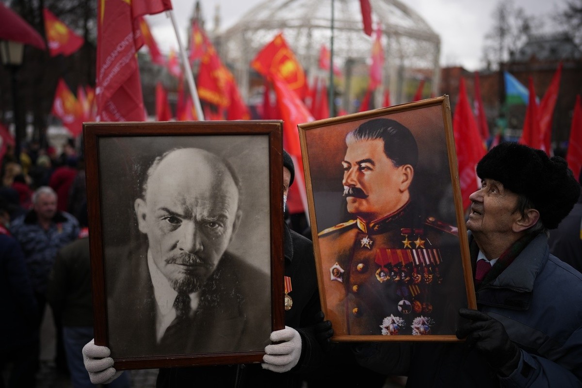 Communists' party supporters hold portraits of Josef Stalin and Vladimir Lenin as they gather during the national celebrations of the 'Defender of the Fatherland Day' near the Kremlin i ...