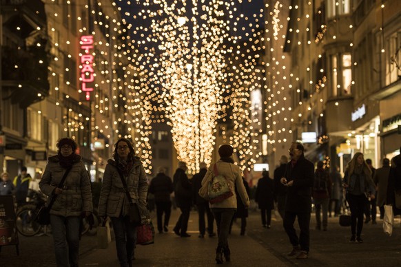 Menschen erledigen ihre Einkaeufe inmitten der Weihnachtsbeleuchtung in Zuerich, aufgenommen am Mittwoch, 14. Dezember 2016. (KEYSTONE/Ennio Leanza)