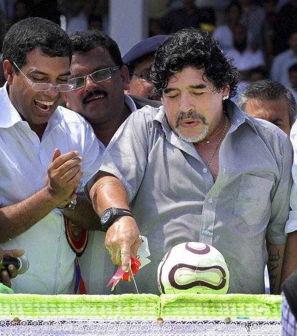 In this Wednesday, Oct. 24, 2012 photo, Argentina soccer legend Diego Maradona, cuts a cake on his birthday as he entertains fans, unseen, in Kannur, Kerala, India. Maradona enthralled thousands of fa ...