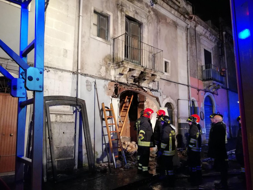 Italian Firefighters gather outside the entrance of a building following a gas explosion which caused the death of two of their colleagues and a man living in the structure in Catania, Sicily Italy, T ...