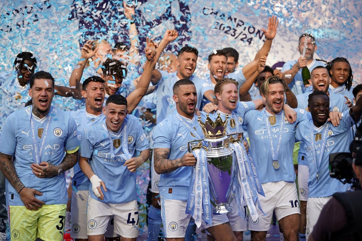 Manchester City's Kyle Walker celebrates with the Premier League trophy after the English Premier League soccer match between Manchester City and West Ham United at the Etihad Stadium in Manchest ...