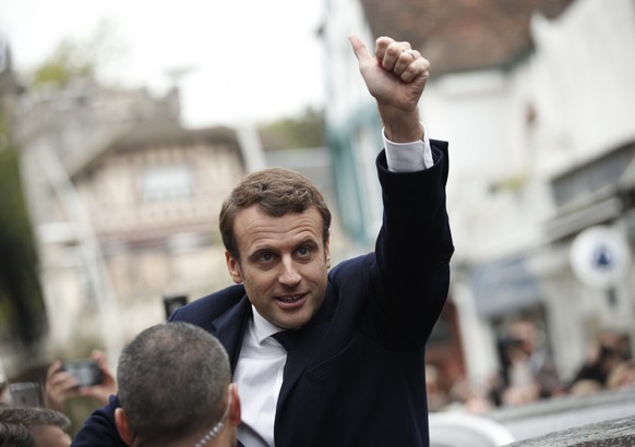 epa05948026 epa05947979 French presidential election candidate for the &#039;En Marche!&#039; (Onwards!) political movement, Emmanuel Macron (C), waves as he leaves after voting in the second round of ...