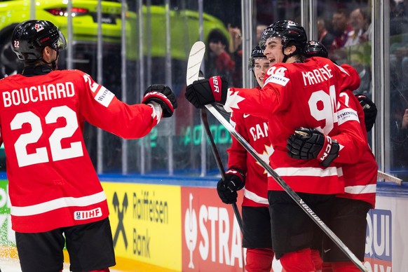 Canada's Porter Martone, right, celebrates with his teammates after scoring his side's first goal during the 2026 IIHF Men's Ice Hockey World Championship preliminary round group B game ...