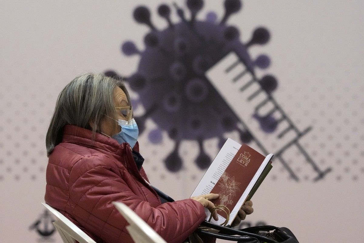 FILE - A woman reads a book in the recovery area of a new vaccination center in Lisbon, Wednesday, Dec. 1, 2021. The World Health Organization?s Europe director says nearly 36 million people in the re ...