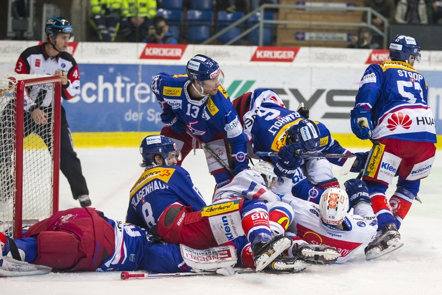 EHC Kloten Torhueter Luca Boltshauser, links, begraben unter einem Haufen von eigenen und gegnerischen Spielern waehrend dem Eishockey-Meisterschaftsspiel der National League zwischen dem EHC Kloten u ...