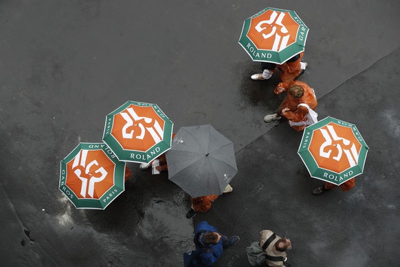 Spectators with umbrellas stroll as rain delayed the start of quarterfinal matches of the French Open tennis tournament at the Roland Garros stadium in Paris, Wednesday, June 5, 2019. (AP Photo/Pavel  ...