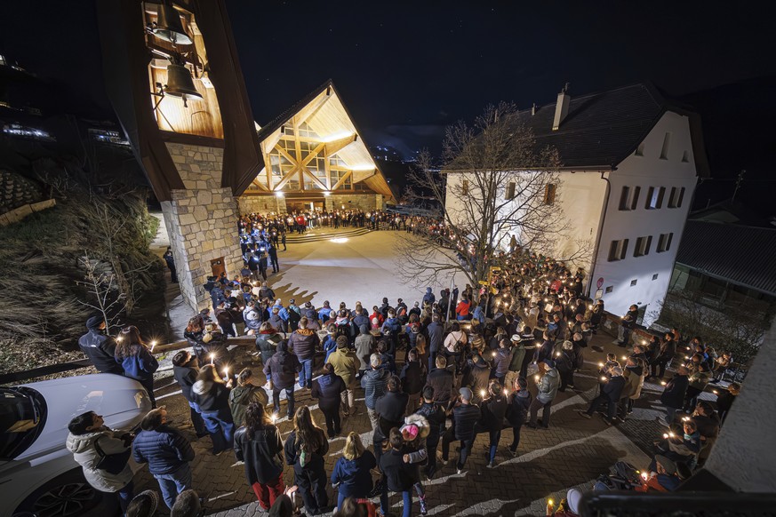 People attend a ceremony following the discovery of 5 ski tourers who had died near Tete Blanche in the Swiss alps mountains, in Vex, Switzerland, Monday, March 11, 2024. Five cross-country skiers who ...