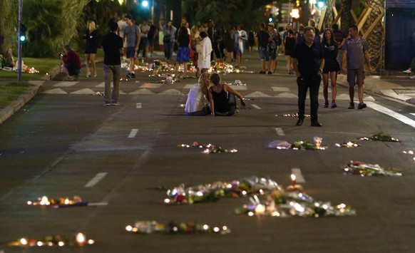 JAHRESRUECKBLICK 2016 - INTERNATIONAL - epa05428723 People walk past flowers and candles on the &#039;Promenade des Anglais&#039; where the truck crashed into the crowd during the Bastille Day celebra ...