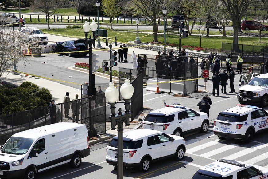 Police officers gather near a car that crashed into a barrier on Capitol Hill in Washington, Friday, April 2, 2021. (AP Photo/J. Scott Applewhite)