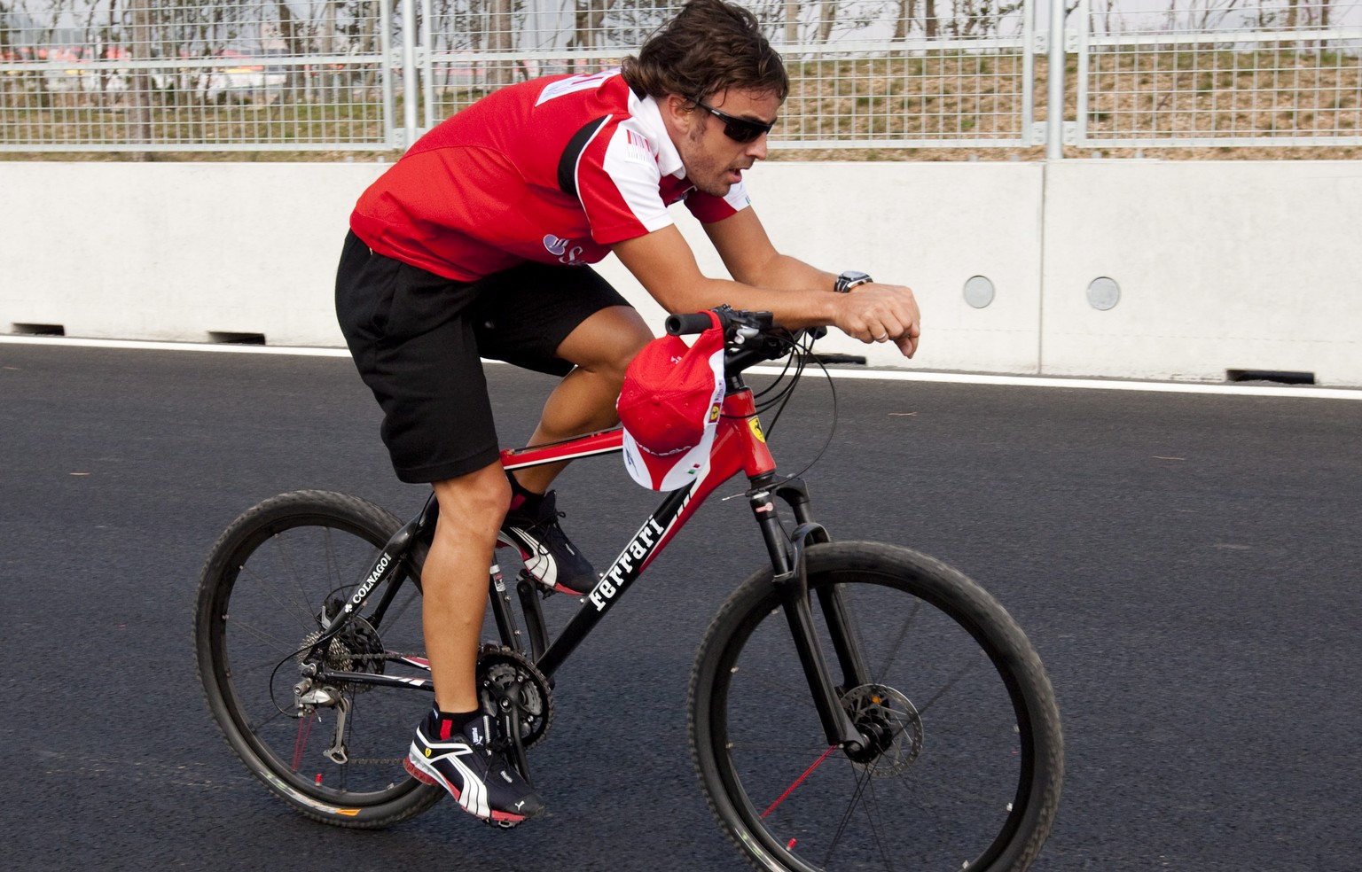 epa09005305 (FILE) - Spanish Formula One driver Fernando Alonso (R) of Scuderia Ferrari cycles on the race track at the Korean International Circuit in Yeongam, South Korea, 21 October 2010 (re-issued ...