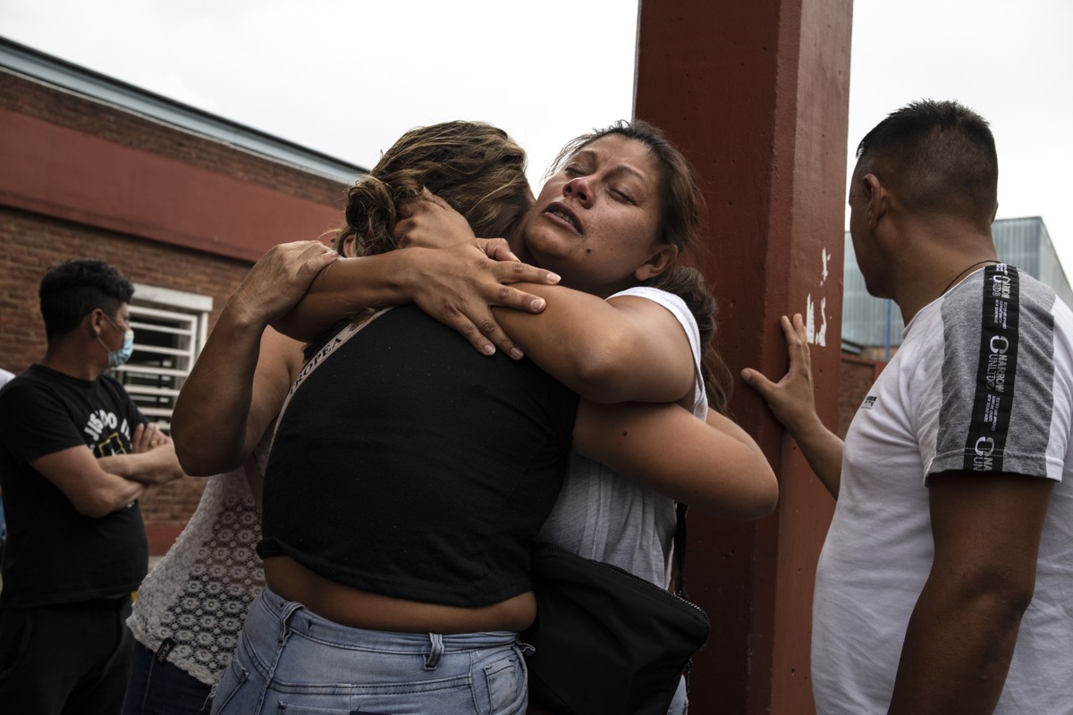 A woman, facing the camera, is consoled after learning her brother died from consuming toxic cocaine, outside the Bocalandro Hospital near the "Puerta 8" neighborhood, a suburb north of Buen ...