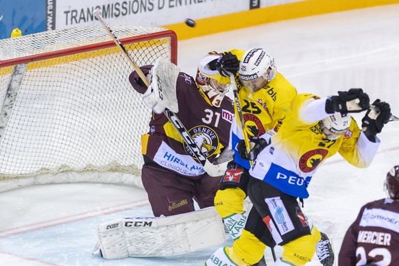 Les joueurs du club bernois, Andrew Ebbett, centre, et Marc Kaempf, droite, a la lutte pour le puck le gardien genevois, Stephane Charlin, gauche, lors du match du championnat suisse de hockey sur gla ...