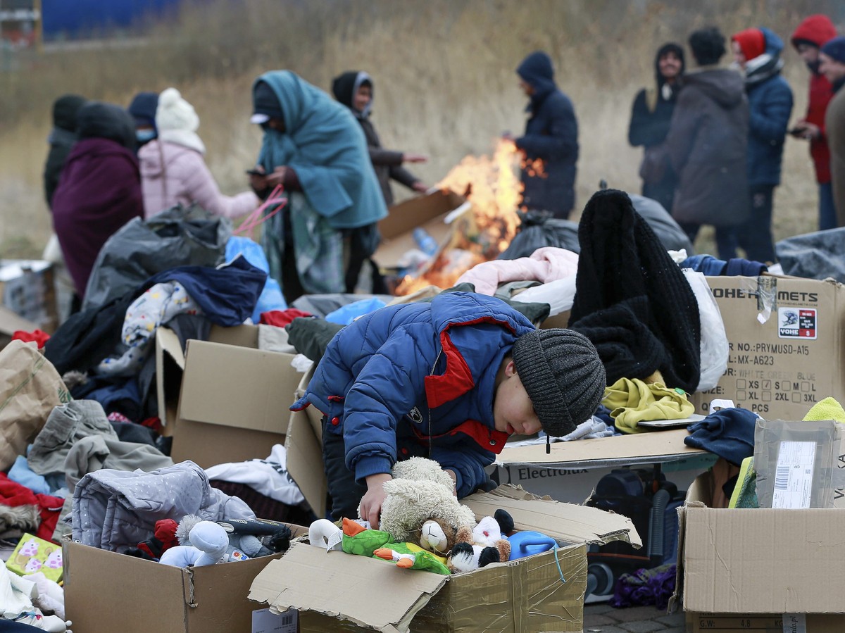 A child collects toys near a clothes donating point as refugees fleeing conflict in Ukraine arrive at the Medyka border crossing in Poland, Monday, Feb. 28, 2022. The head of the United Nations refuge ...