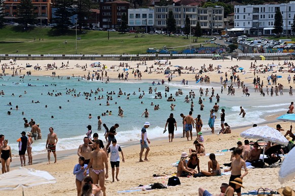 epa09649190 Members of the public are seen at Bondi Beach in Sydney, Australia, 19 December 2021. Sydney is set to peak above 30C on Saturday, as a heatwave moves across the country. EPA/BIANCA DE MAR ...