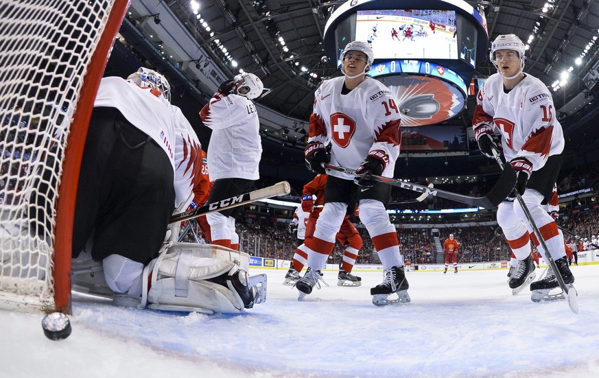 Switzerland goalie Luca Hollenstein and teammates Simon Le Coultre (4), Sandro Schmid (14) and Matthew Verboon (15) react after Russia&#039;s Kirill Slepets scores during the first period of the bronz ...