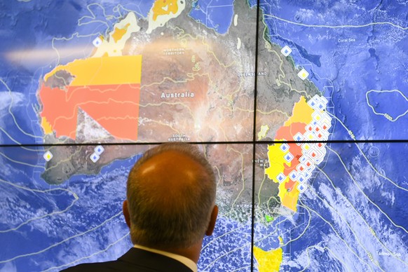 epa07990797 Australian Prime Minister Scott Morrison looks at a screen as he gets a briefing on the bushfire situation in New South Wales and Queensland during a visit to the Australian Government Cri ...