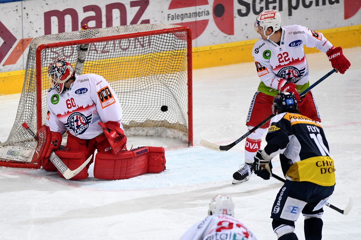 From left: Rapperswil's goalkeeper Melvin Nyffeler, Ambri's player Bryan Flynn and Rapperswil's player Cedric Haechler for the 1 - 0 goal, during the preliminary round game of National  ...