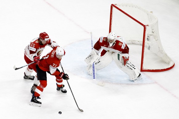 Belarus&#039; defender Pavel Vorobey, left, vies for the puck with Switzerland&#039;s forward Enzo Corvi #71 past Belarus&#039; goaltender Mikhail Karnaukhov, right, during the IIHF 2018 World Champio ...