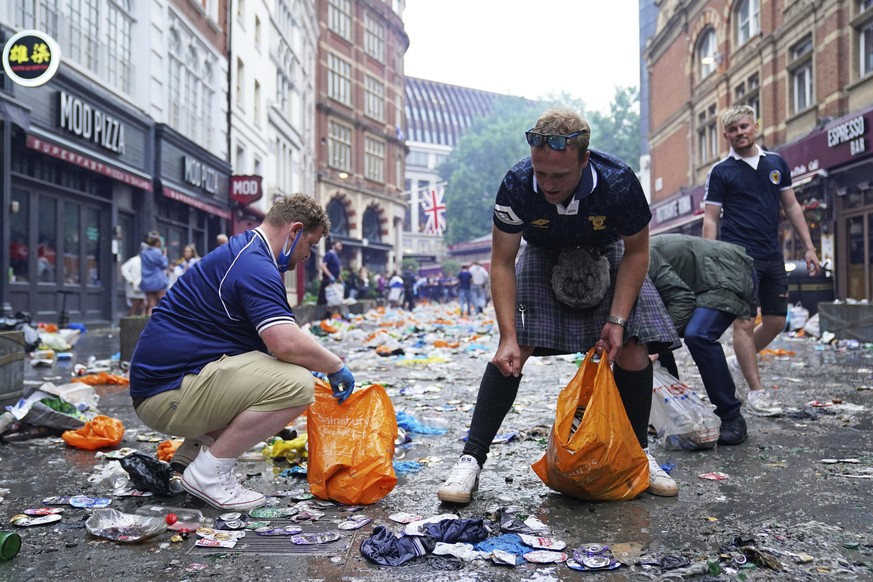 Scotland fans helps clean up litter after fans gathered in Irving Street near Leicester Square prior to the Euro 2020 soccer championship group D match between England and Scotland, in London, Friday, ...