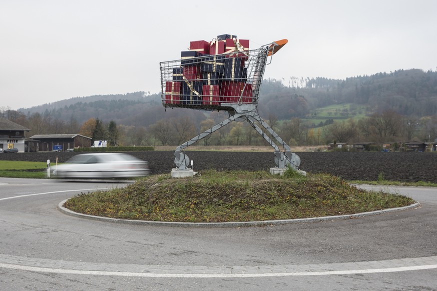 Ein ueberdimensionaler Einkaufswagen mit Geschenkpaketen steht in einem Kreisel, am Donnerstag, 27. November 2014 in Biel. (KEYSTONE/Peter Klaunzer)