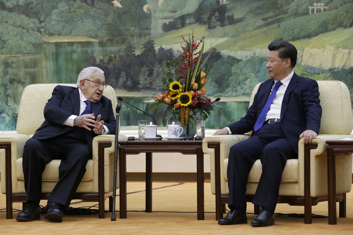 FILE - China's President Xi Jinping, right, listens to former U.S. Secretary of State Henry Kissinger, who led the China-U.S Track Two Dialogue, during a meeting at the Great Hall of the People i ...