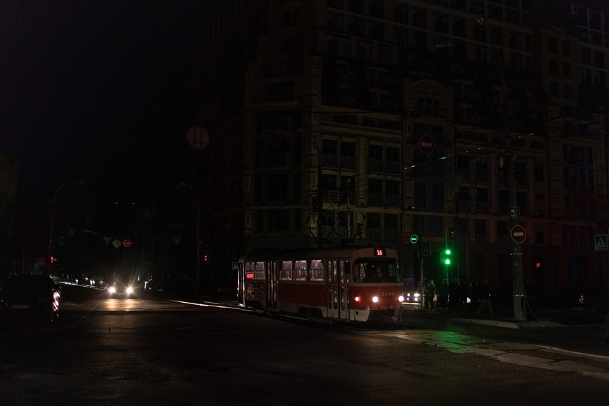 epa10277575 A tram moves while the street lights are switched off, in downtown Kyiv, Ukraine, 31 October 2022. Scheduled power cuts were introduced in Kyiv, power operator Ukrenergo said, following th ...