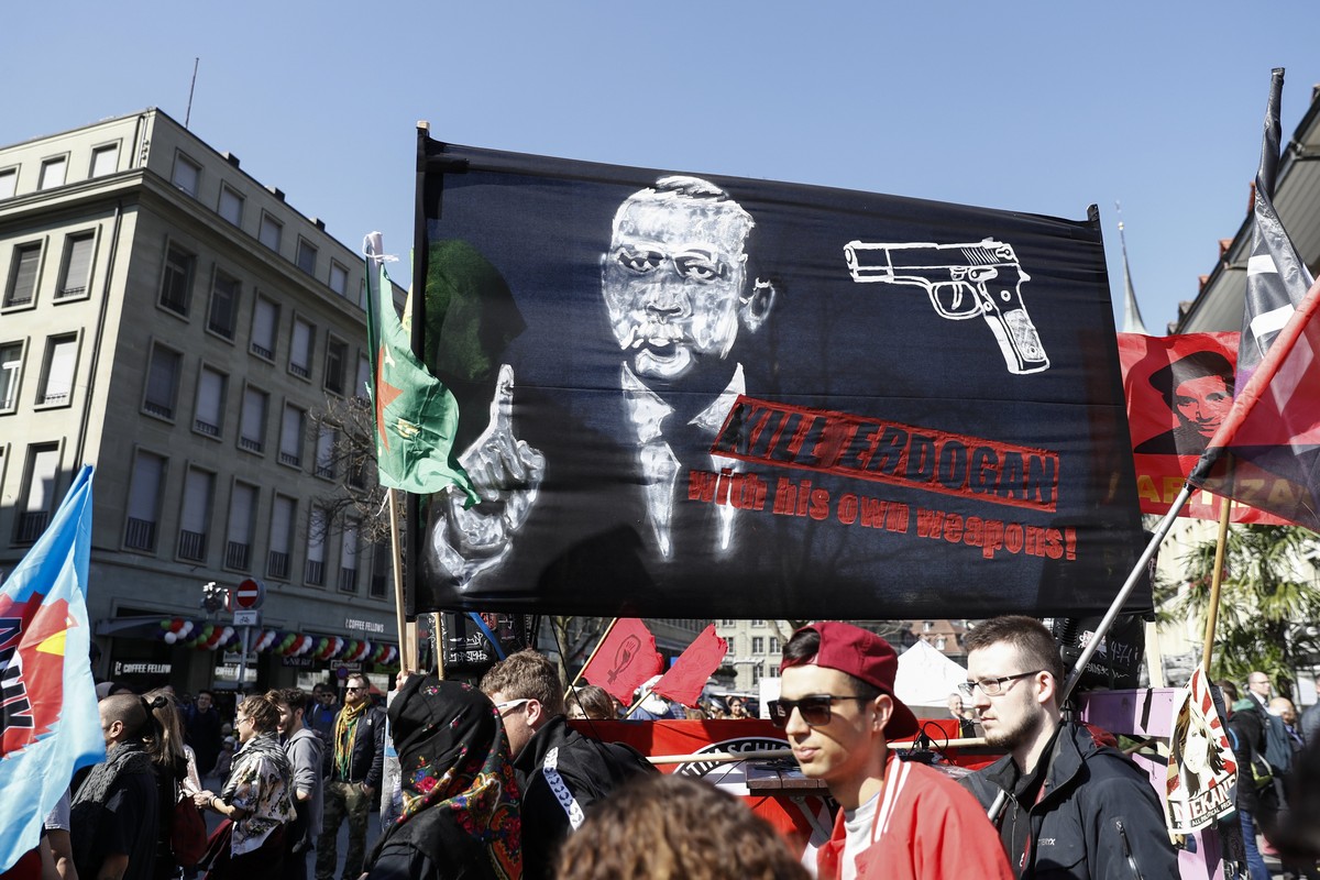 epa05870523 A banner reads; 'Kill Erdogan with his own weapons', as protesters march during a demonstration against the Turkish President Recep Tayyip Erdogan, in Bern, Switzerland, 25 March ...