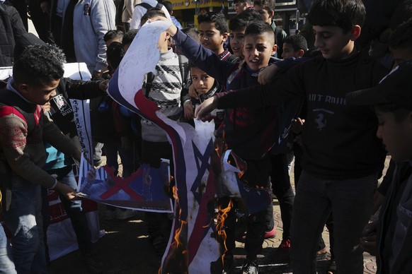 Palestinians burn a picture of Israeli lawmaker Itamar Ben-Gvir during a protest at the main square in Rafah refugee camp, southern Gaza Strip, against the Jews visit to the Temple Mount, known to Mus ...