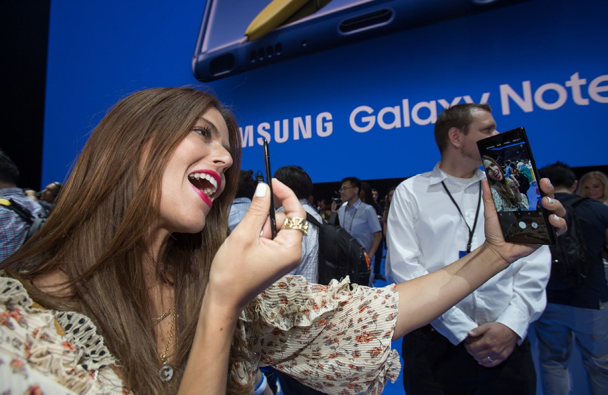 epa06939621 A handout photo made available by Samsung Electronics Co., Ltd shows a woman taking a selfie with Samsung Electronics Co.'s new Galaxy Note 9 smartphone during a rollout event at Barc ...
