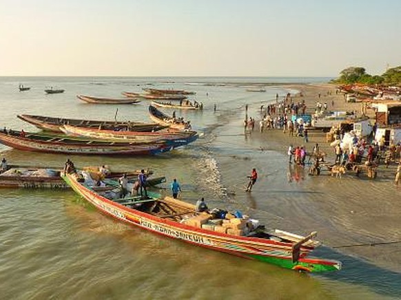People With Boats At Gambia River Against Clear Sky - Stock-Fotografie
