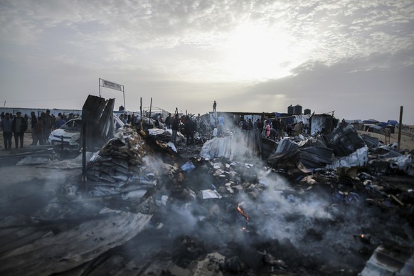 Palestinians look at the destruction after an Israeli strike where displaced people were staying in Rafah, Gaza Strip, Monday, May 27, 2024. Palestinian health workers said Israeli airstrikes killed a ...