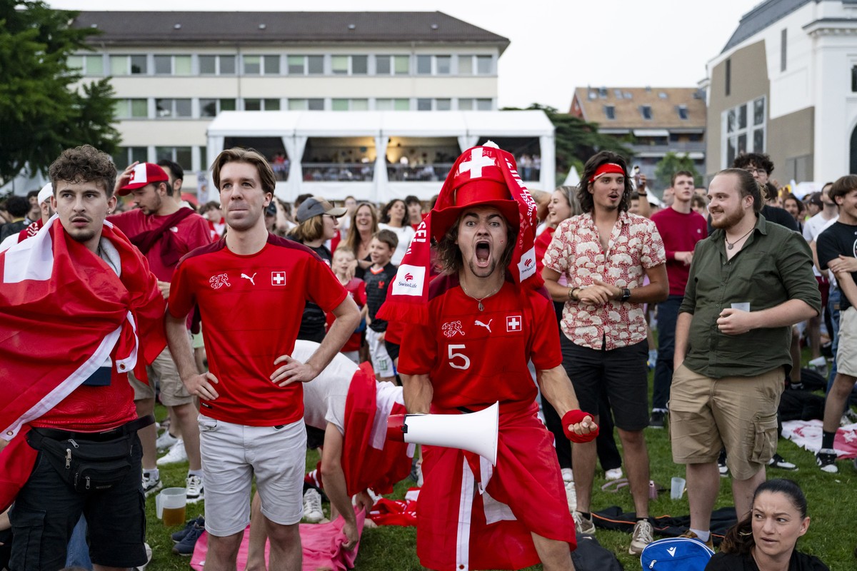Des supporters de l'equipe de suisse de football celebrent le but de Xherdan Shaqiri en regardant sur un ecran geant dans une fan zone le match de l'Euro 2024 entre l'Ecosse et la Suiss ...