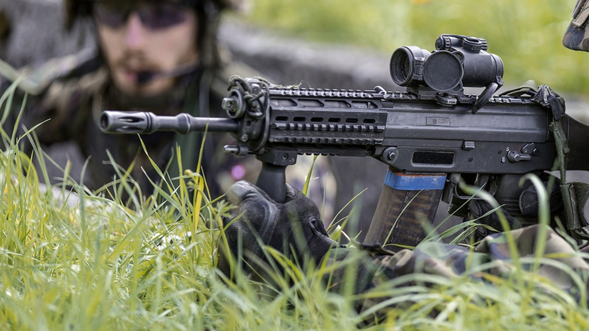 A parascout recruit in a trench holds a SG 550 assault rifle in his hands, pictured on June 17, 2013, in the recruit school for parascouts of the Swiss army in Altmatt, canton of Schwyz, Switzerland.  ...