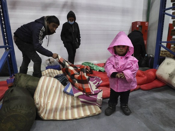 Migrants settle for the night in the logistics center in the checkpoint &quot;Kuznitsa&quot; at the Belarus-Poland border near Grodno, Belarus, on Tuesday, Nov. 16, 2021. Polish border forces say they ...