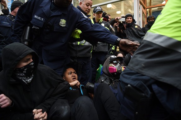 epa05734769 Police step over demonstrators who block one of the entrances to the route of the inauguration parade at 10th Street near Pennsylvania Avenue to protest Donald J. Trump who will take the o ...