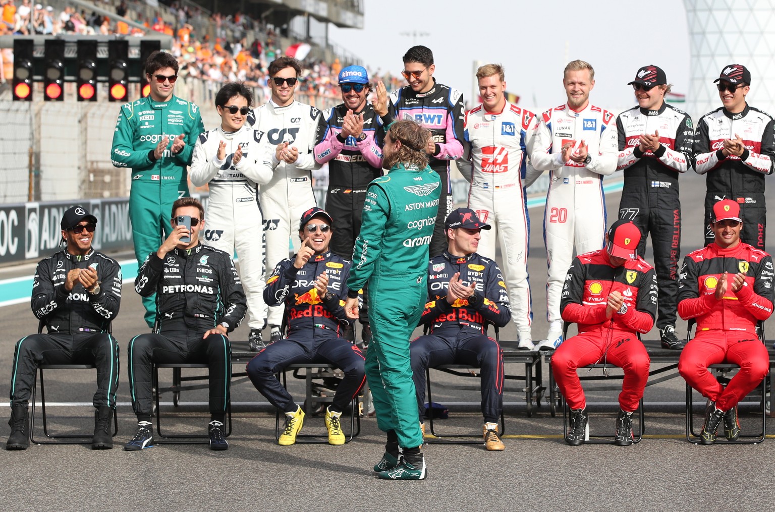 epa10315689 Retiring German Formula One driver Sebastian Vettel of Aston Martin (C) waves to spectators as he joins drivers to pose for the &#039;end of season&#039; group photo before the Abu Dhabi F ...