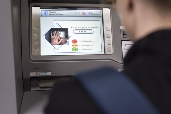 ZUM THEMA GELD STELLEN WIR IHNEN HEUTE, DONNERSTAG, 1. OKTOBER 2015, FOLGENDES NEUES BILDMATERIAL ZUR VERFUEGUNG --- A woman withdraws money from a cash dispenser, photographed in Zurich, Switzerland, ...