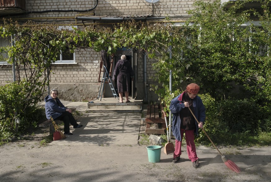 epa11333870 Locals clean debris following a shelling on the outskirts of Volchansk, Kharkiv region, Ukraine, 11 May 2024, amid the Russian invasion. Some people decided not to evacuate but remain in t ...