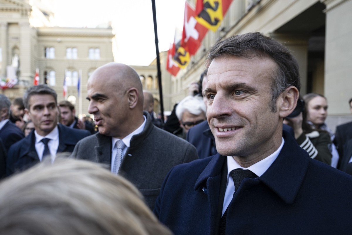 Switzerland President Alain Berset, left, and French President Emmanuel Macron, right, greet people in front of the Federal Palace, the Swiss Parliament building, in Bern, Switzerland, Wednesday, Nove ...