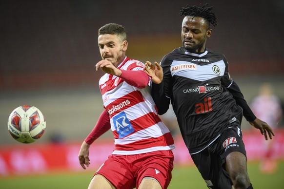 Le defenseur valaisan Ayoub Abdellaoui, gauche, lutte pour le ballon avec l&#039;attaquant luganais Asumah Abubakar, droite, lors de la rencontre de football a huis clos de Super League entre FC Sion  ...