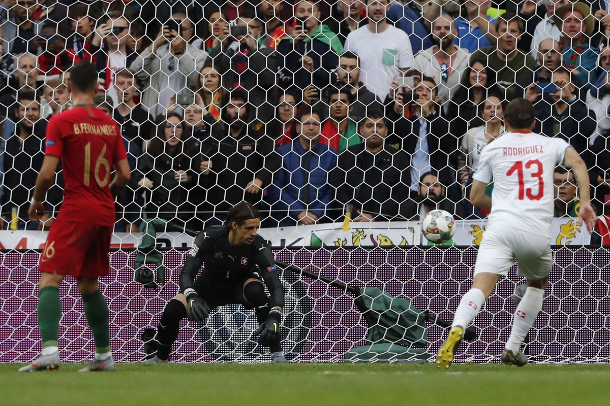 Switzerland goalkeeper Yann Sommer, center, fails to save the ball as Portugal's Cristiano Ronaldo scores the opening goal during the UEFA Nations League semifinal soccer match between Portugal a ...